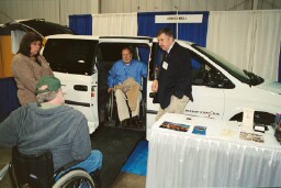 Stan Kosloski, Protection and Advocacy, gives the van from advanced Wheels his accessibility test while Ed Basile talks to consumers.